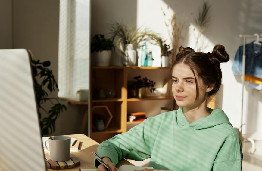 Woman in Green Long Sleeve Shirt Sitting by the Table