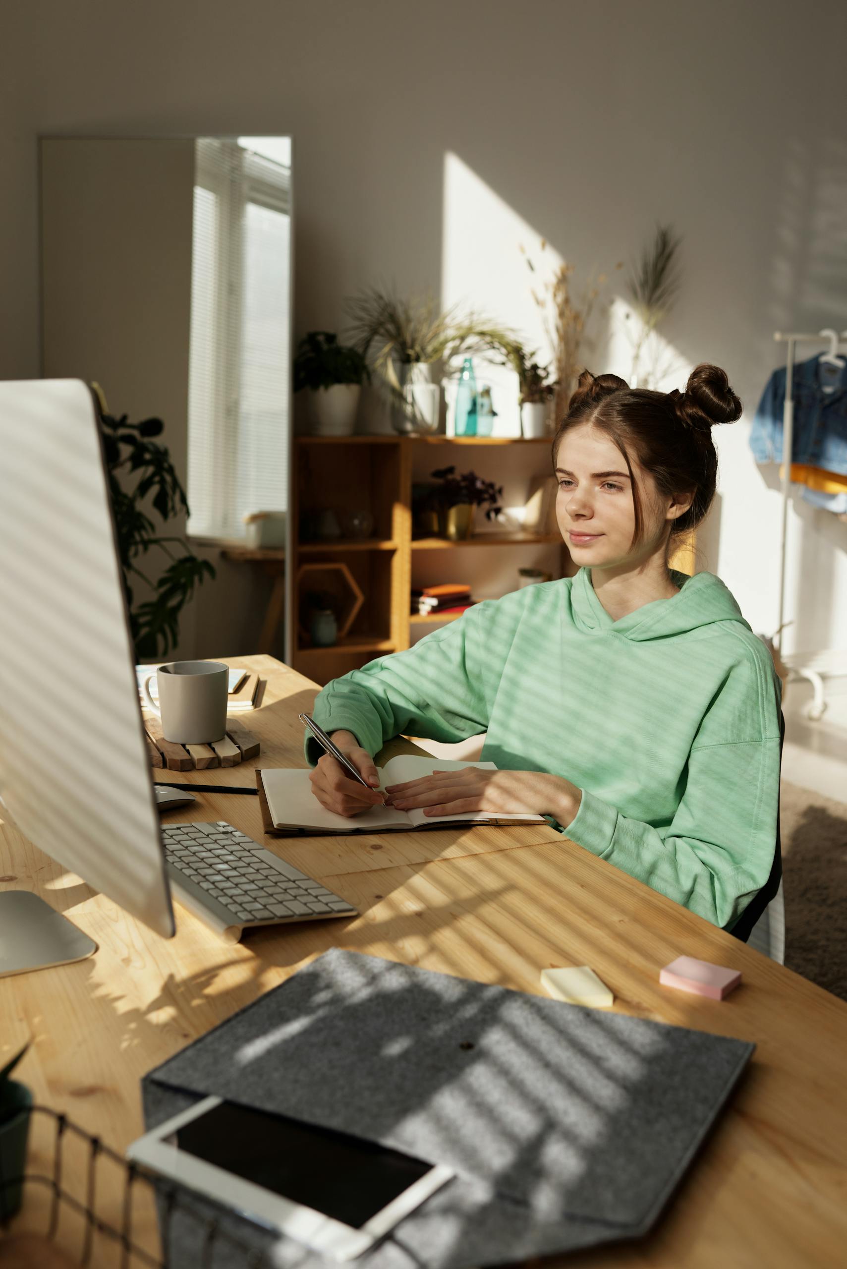 Woman in Green Long Sleeve Shirt Sitting by the Table