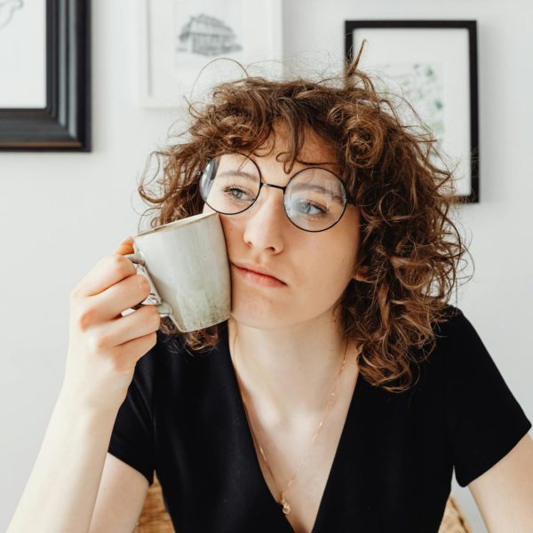 Curly-Haired Woman Holding a Coffee Mug